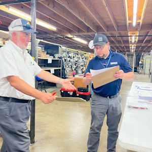 two men looking over inventory sheet in a warehouse